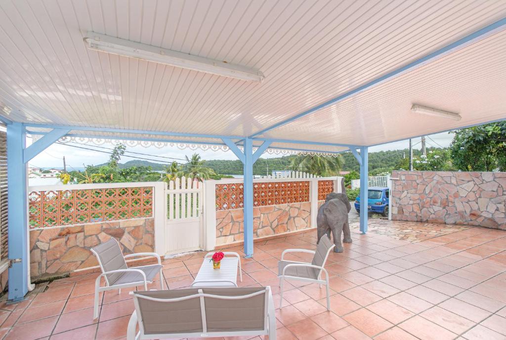 勒沃克兰La Villa Bleue Topaze RDC - Vue Mer的一只大象站在带遮阳伞的庭院