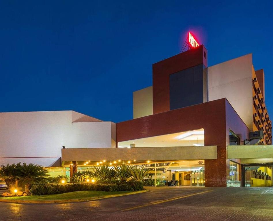 a large building with a neon sign on top of it at Hotel Thomasi Express - Londrina in Londrina