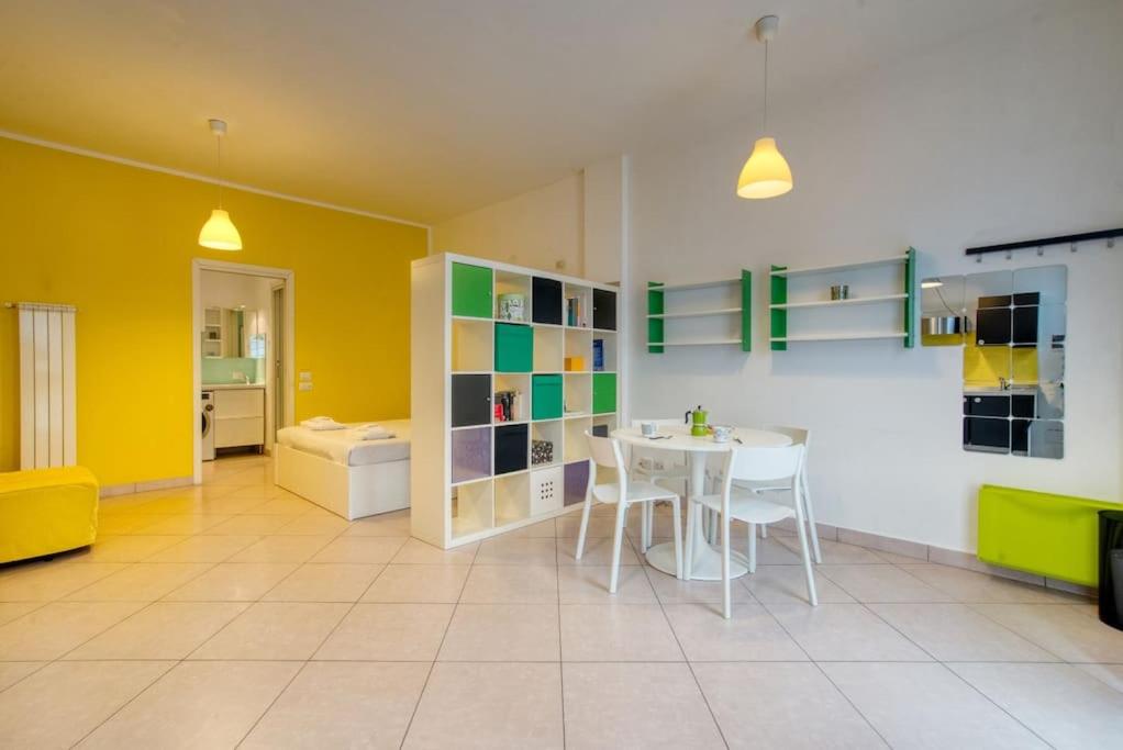 uma sala de estar com uma mesa e uma parede amarela em Il Giardino del naviglio-Studio em Milão