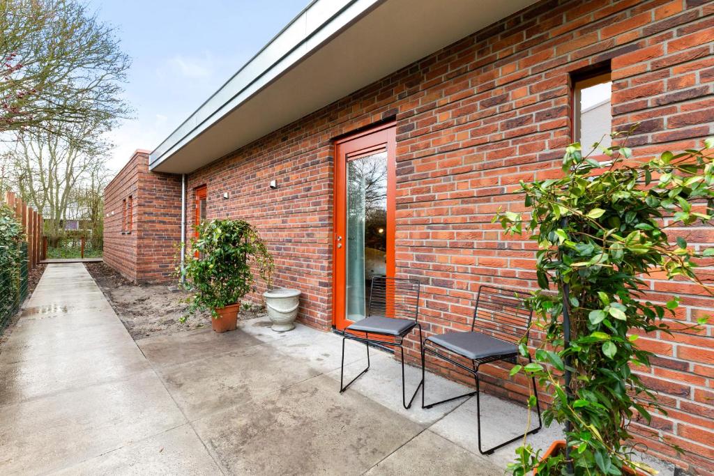 une maison en briques avec 2 chaises sur une terrasse dans l'établissement Hello Zeeland - Studio's Duinenburg 10, à Domburg