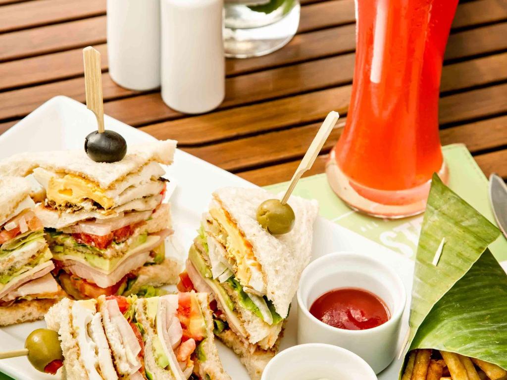 a white plate with a sandwich with olives and ketchup at Hotel Ibis Samui Bophut in Bophut
