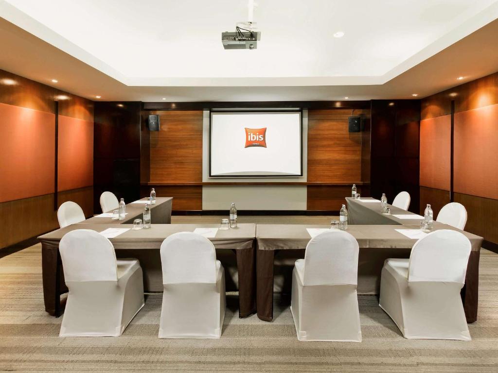 a conference room with a large table and white chairs at Hotel Ibis Samui Bophut in Bophut