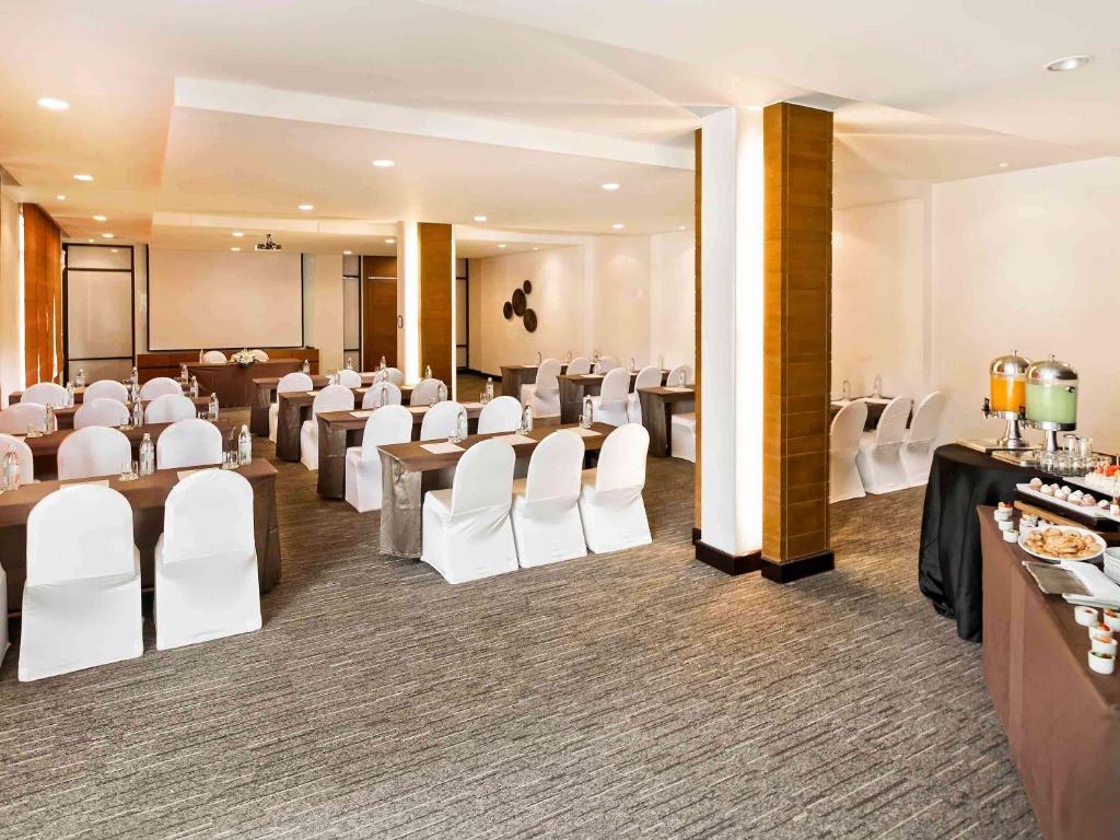 a banquet hall with white chairs and tables in a room at Hotel Ibis Samui Bophut in Bophut
