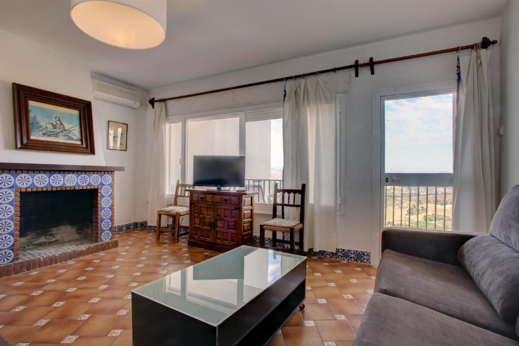 salon z kanapą i kominkiem w obiekcie Apartamentos Terrazas del Tajo w mieście Ronda