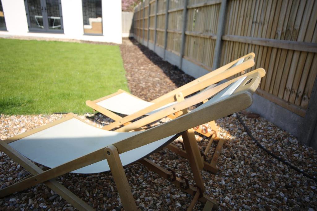 a chair sitting in a yard next to a fence at Sunbeam and Sundance Cosy House in Whitstable