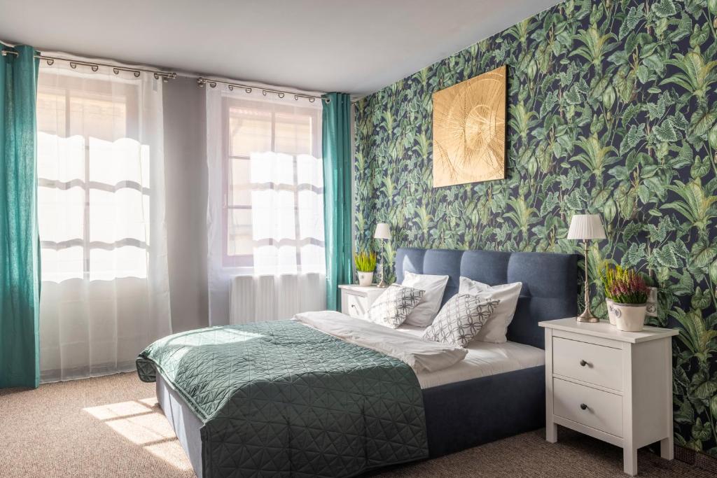 a bedroom with a bed and a green wall at Staycity Apartments Sukiennice 6 in Wrocław