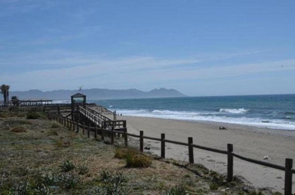 una playa con una valla de madera y el océano en Piso lujo el toyo, en Retamar