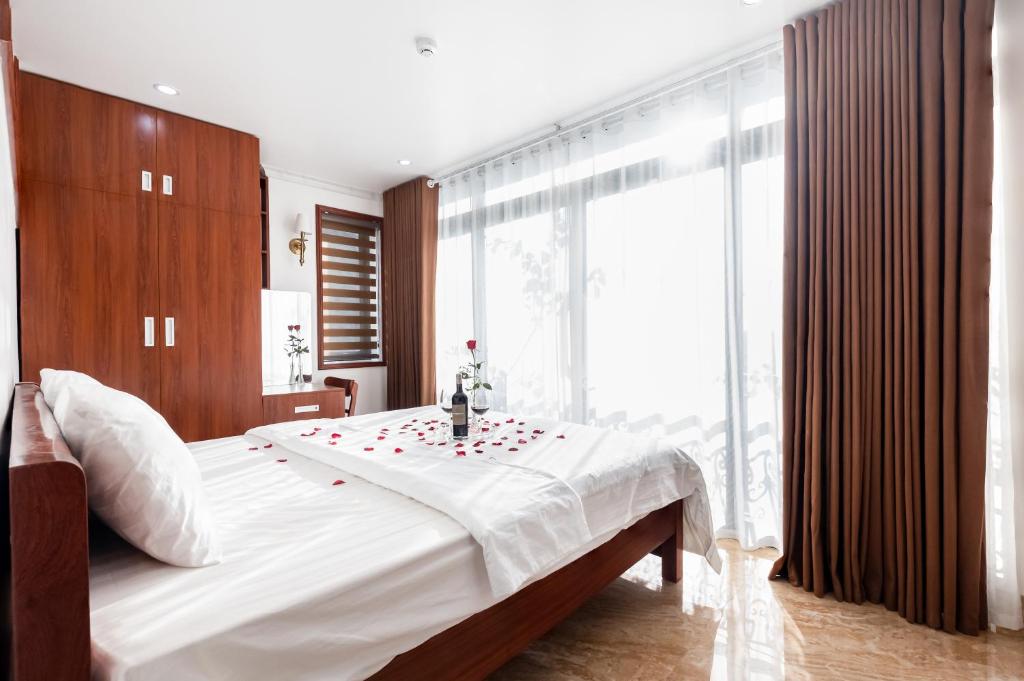 a bedroom with a large bed with red roses on it at CHÉRIE HOMEHOTEL in Ha Long