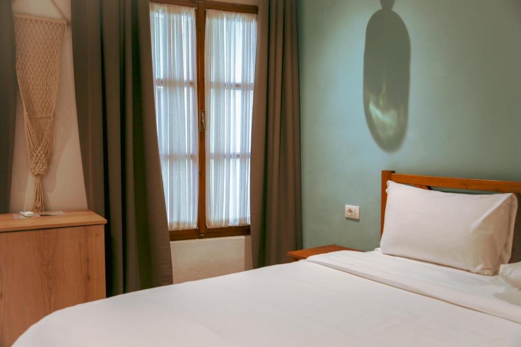 - une chambre avec un lit blanc et une fenêtre dans l'établissement Agora Bed & Breakfast, à Vlorë