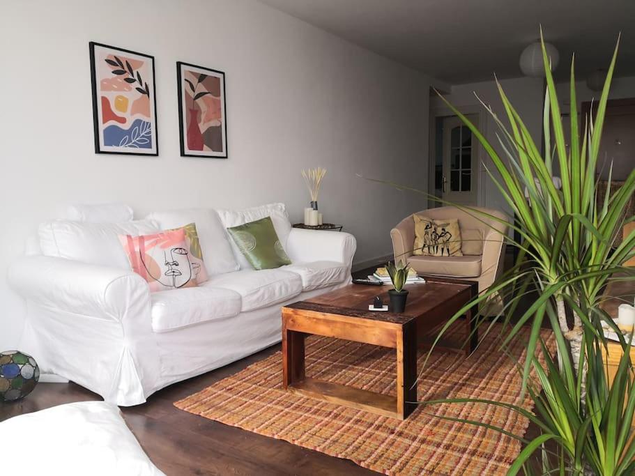 Spacious and light flat with beautiful views في سانتاندير: غرفة معيشة مع أريكة بيضاء وطاولة قهوة