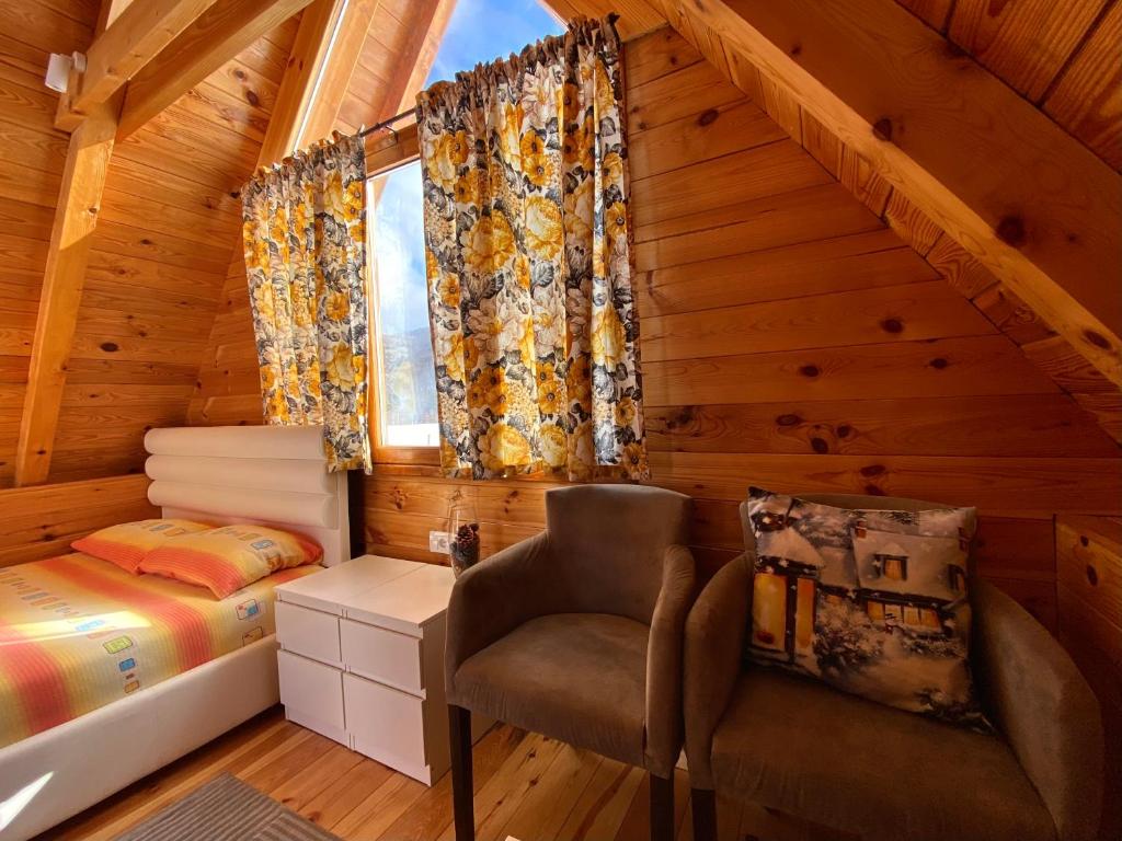 a bedroom in a log cabin with a bed and a chair at Blue Village 8 in Kolašin