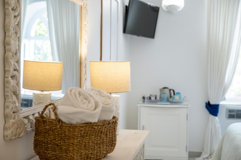 a bedroom with two lamps and a basket on a table at Villa Dalu in Positano