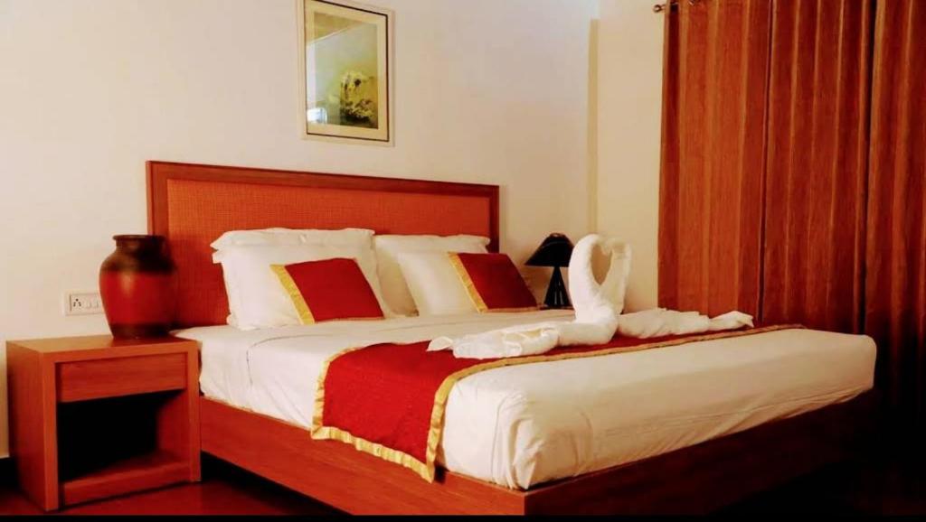 a bedroom with a large bed with a white bedspread at Pearlspot Hotel in Kumarakom