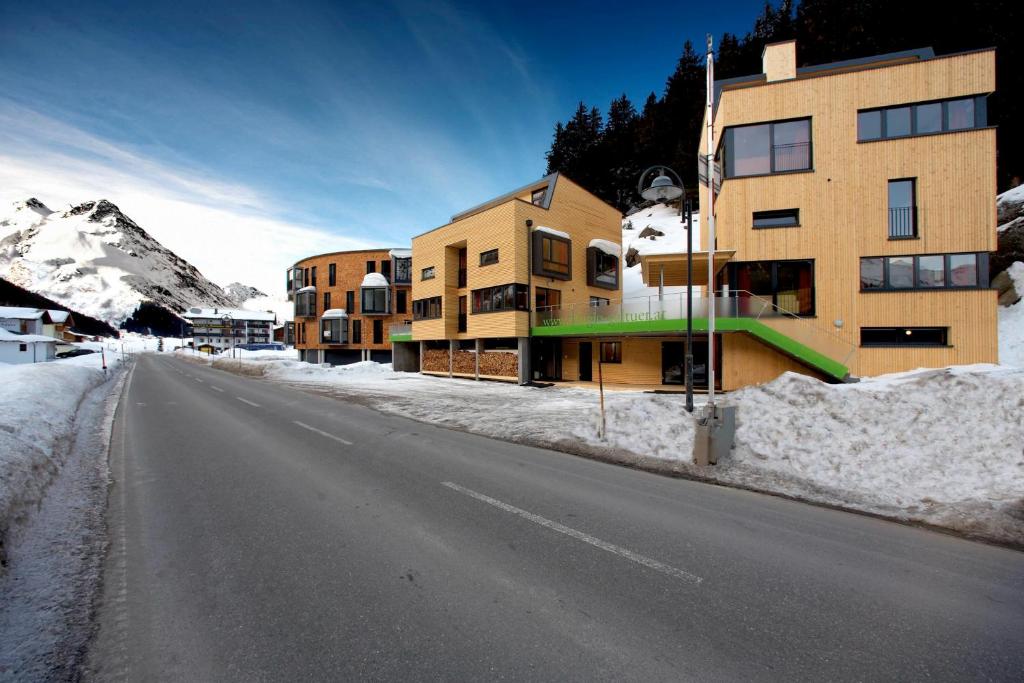 una calle vacía en la nieve al lado de un edificio en Rifugio Galtür - die 2 Ferienhäuser, en Galtür