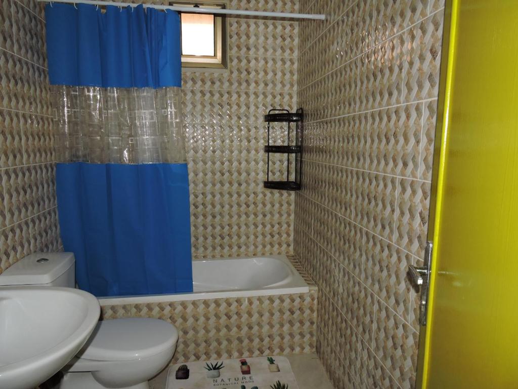 a bathroom with a toilet and a tub and a sink at Mango haus in Aqaba