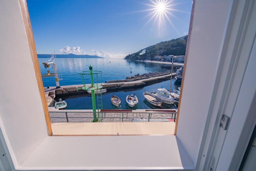 una ventana con vistas al puerto deportivo en Wohnung Porto, en Mošćenička Draga