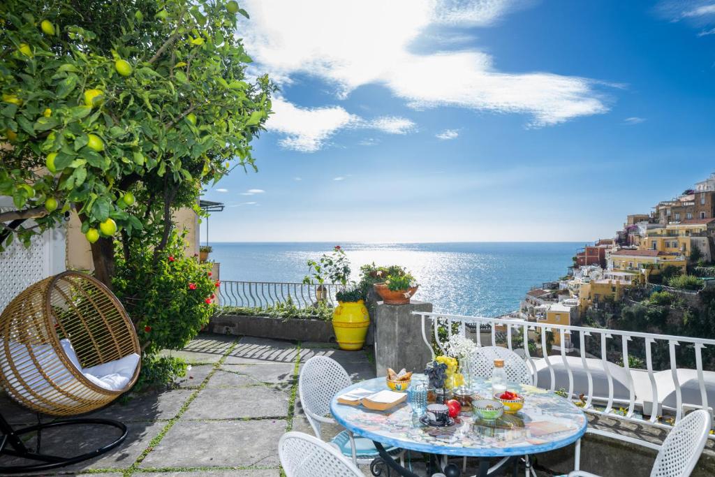 a patio with a table and chairs and the ocean at Villa Dalu in Positano
