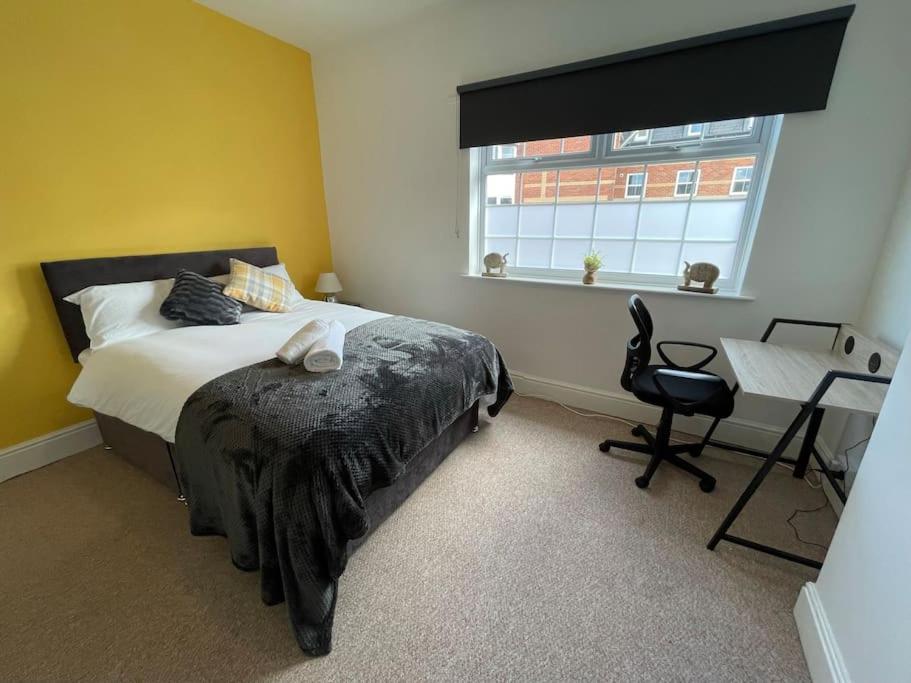 a bedroom with a bed and a desk and a window at Lovely Seaside House in Cleethorpes - sleeps 6 in Cleethorpes