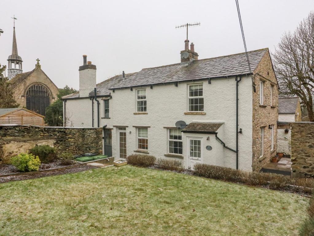 a white house with a yard in front of it at Lavender Cottage in Sedbergh