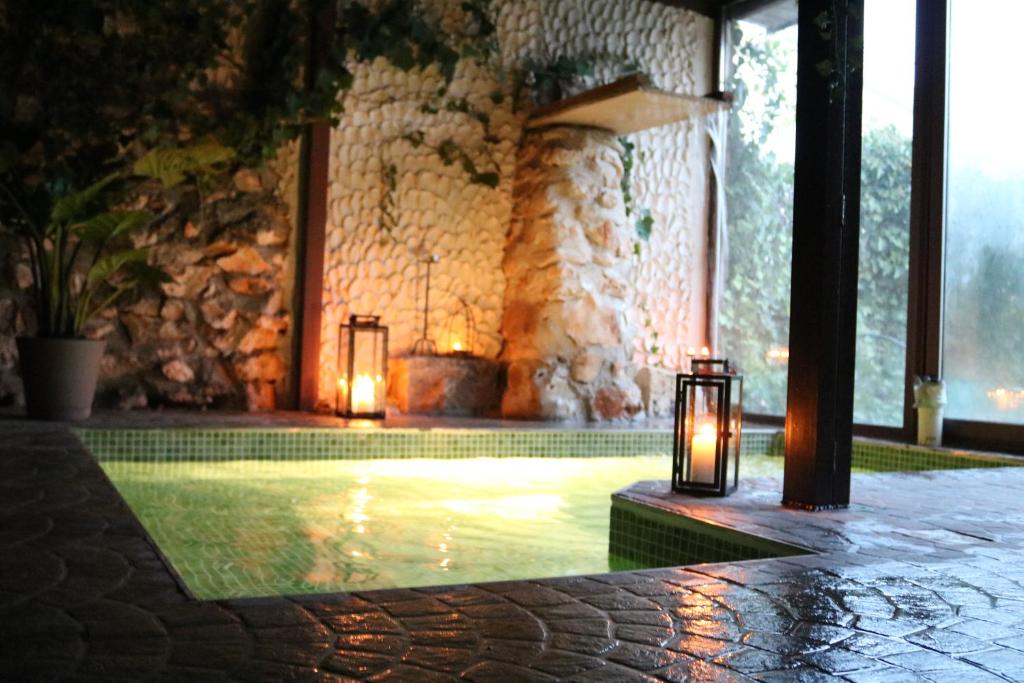 una piscina con velas en un edificio de piedra en Spa los Balcones, en Loranca de Tajuña