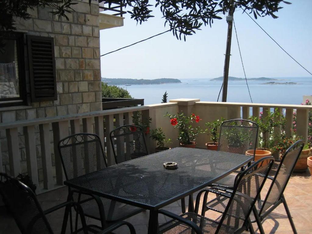 ein Tisch und Stühle auf einem Balkon mit Blick auf das Wasser in der Unterkunft Apartment Stella in Mlini