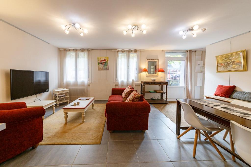 ラ・ブルブールにあるLe Classique de Claireの赤い家具とピアノ付きのリビングルーム