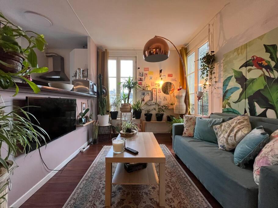 uma sala de estar com um sofá e uma mesa em Le coin vert - 30'min de Paris 1km du RER em Chennevières-sur-Marne