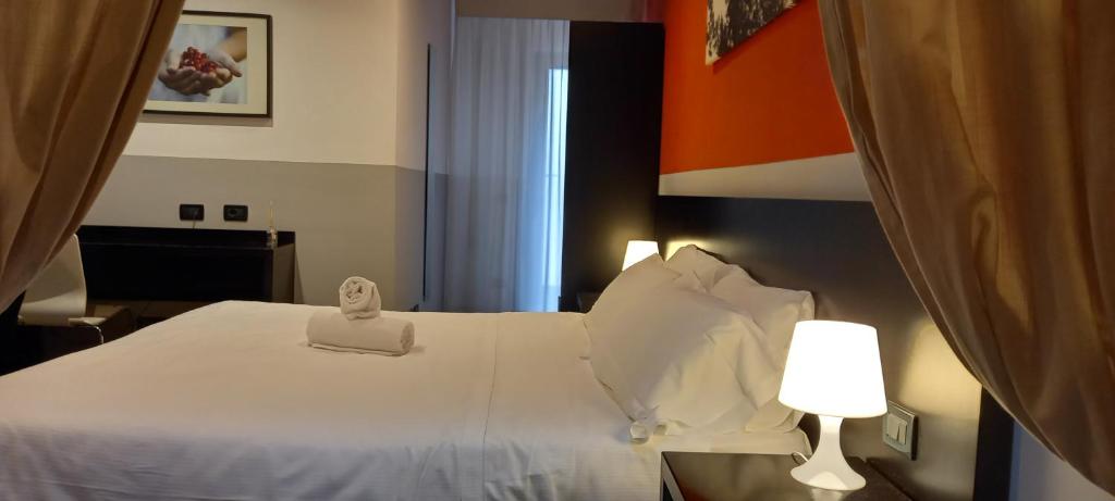 una camera d'albergo con letto bianco e lampada di Hotel Aniene a Roma