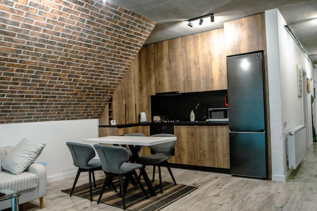a kitchen with a table and chairs and a refrigerator at Cozy Apartment in Floreşti