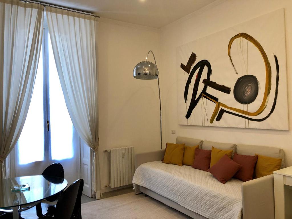 un soggiorno con letto e tavolo con tavolo e tavolo di Casa Alberto da Giussano, elegante bilocale in centro con balcone sul parco a Milano