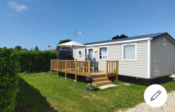 a white tiny house with a porch and a grill at Mobil home-Les Lins Bleus in Biville-sur-Mer