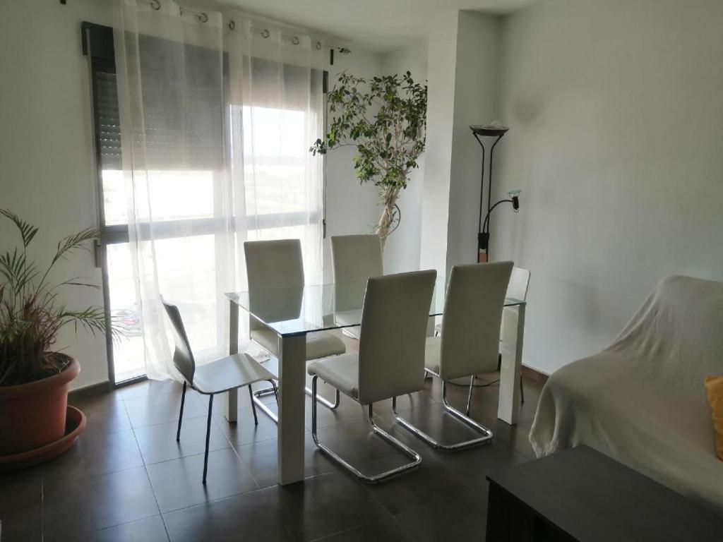 a dining room table and chairs in a room at Apartamento Gloria Patricia in Alcantarilla