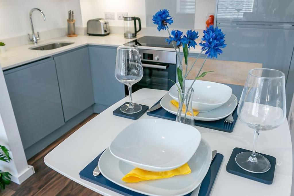 a kitchen with a table with plates and wine glasses at *20% off Monthly* St Albans City Centre Apartment in St. Albans