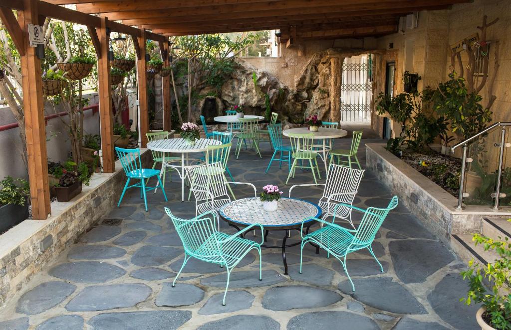 un patio con mesas y sillas en Domus Bat Galim Hotel, en Haifa