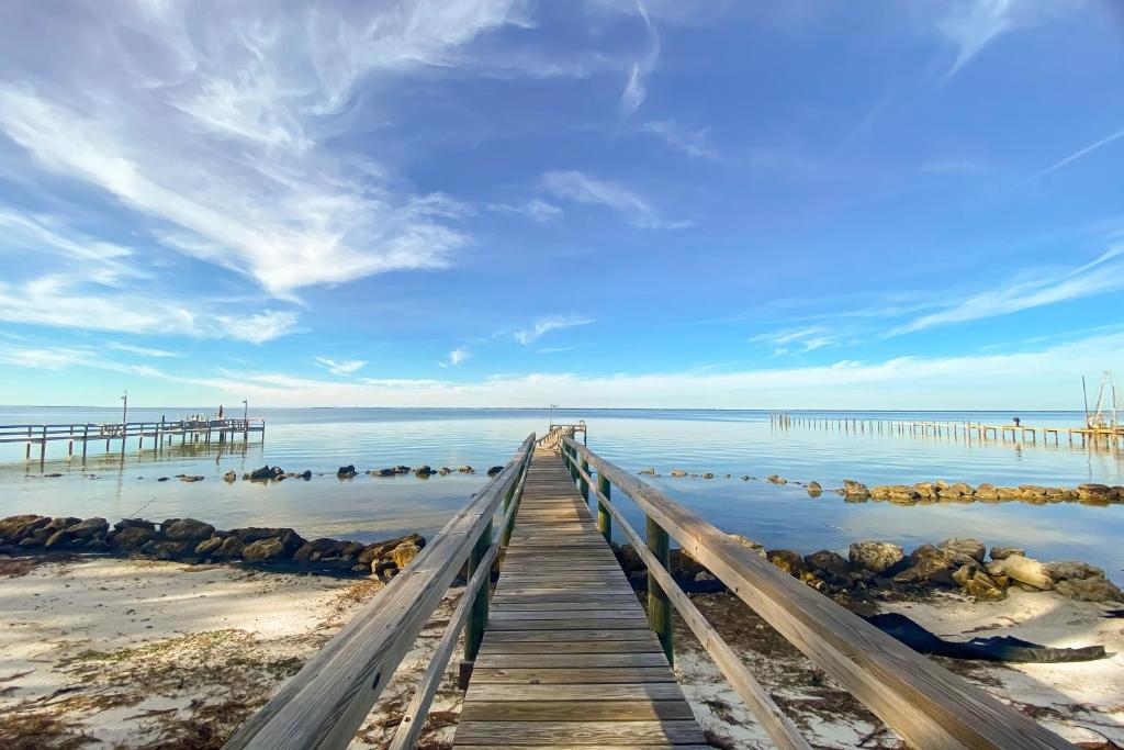 a wooden pier stretches out into the water at Anchor's Aweigh in St. George Island