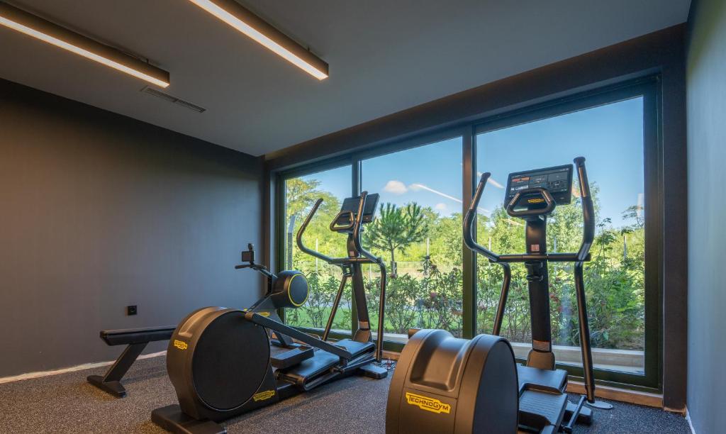 a gym with two exercise bikes and a large window at HVD Reina del Mar - Premium Spa Service & Free Parking in Obzor