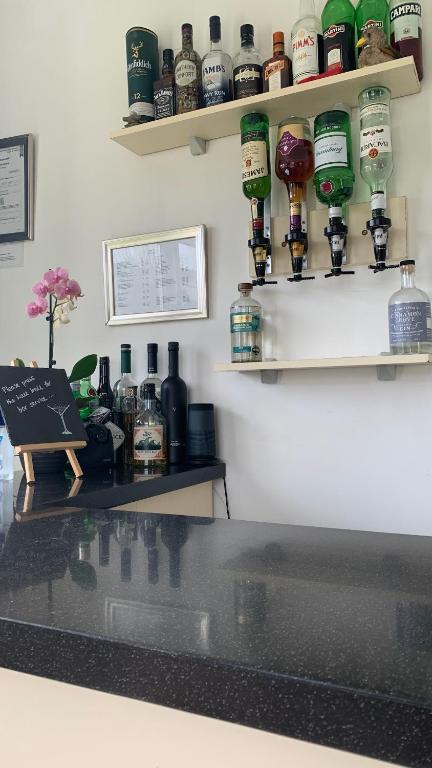 a bar with bottles of alcohol on the wall at Ramsey House - Luxury Licensed B&B - Parking and Guest Lounge in St. Davids