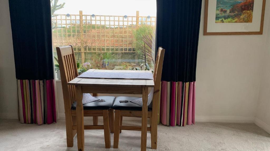 a dining room table with two chairs and a window at Ramsey House - Luxury Licensed B&B - Parking and Guest Lounge in St. Davids