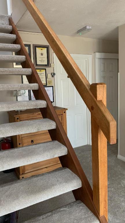 a staircase in a home with a wooden railing at Ramsey House - Luxury Licensed B&B - Parking and Guest Lounge in St. Davids