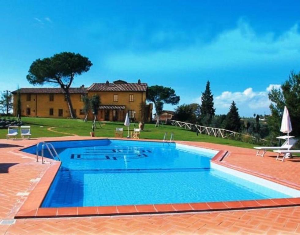 a large swimming pool in front of a house at Appartamento Geranio in San Miniato