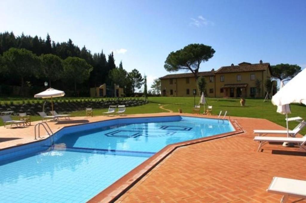 a large swimming pool in a yard with a house at Appartamento Gelsomino in San Miniato