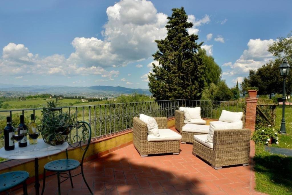un patio con sillas y una mesa con botellas de vino en Appartamento Isabella, en San Miniato