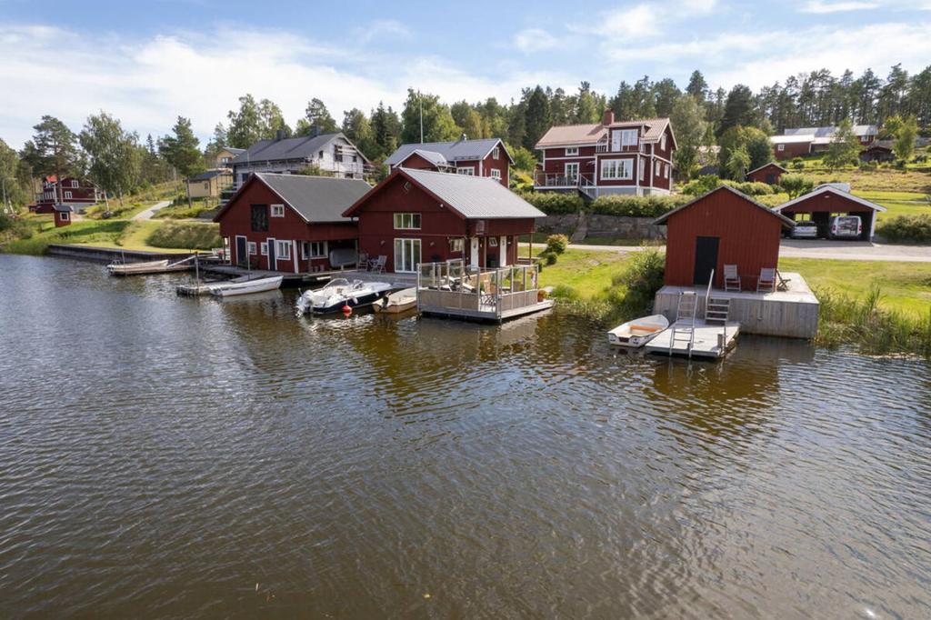 um grupo de casas na água perto de um lago em Seaside Cottage House nr 1, Saltvik Hudiksvall em Hudiksvall