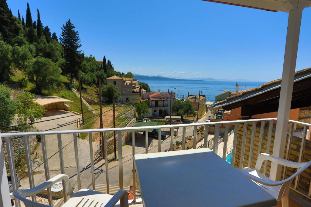 a table and chairs on a balcony with a view of the ocean at Alexandra Apartment in Nisaki