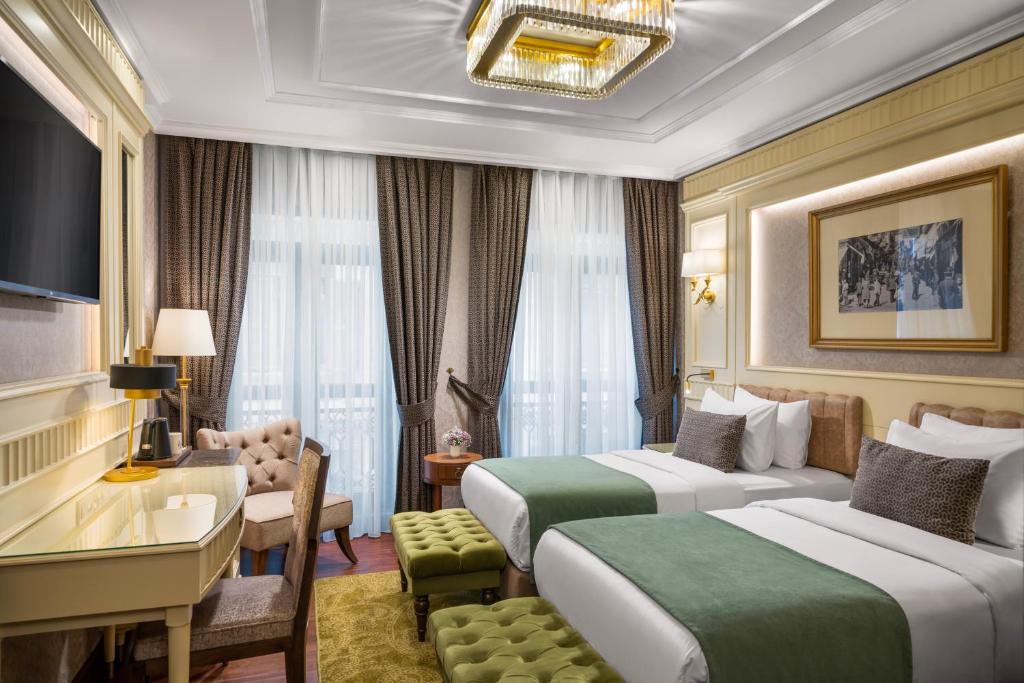 a hotel room with two beds and a desk at Aspera Hotel Golden Horn in Istanbul