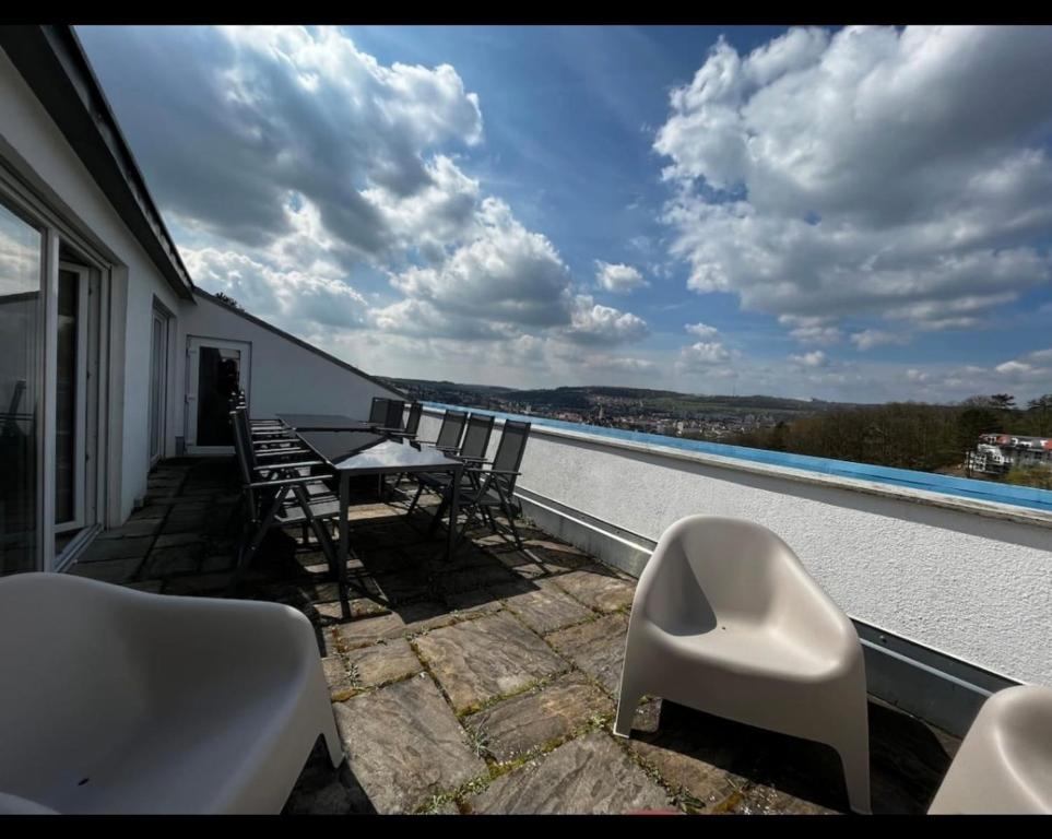 a balcony with a table and chairs and a view of the water at Penthouse perfekt für Teams, Familien und Gruppen in Bad Mergentheim