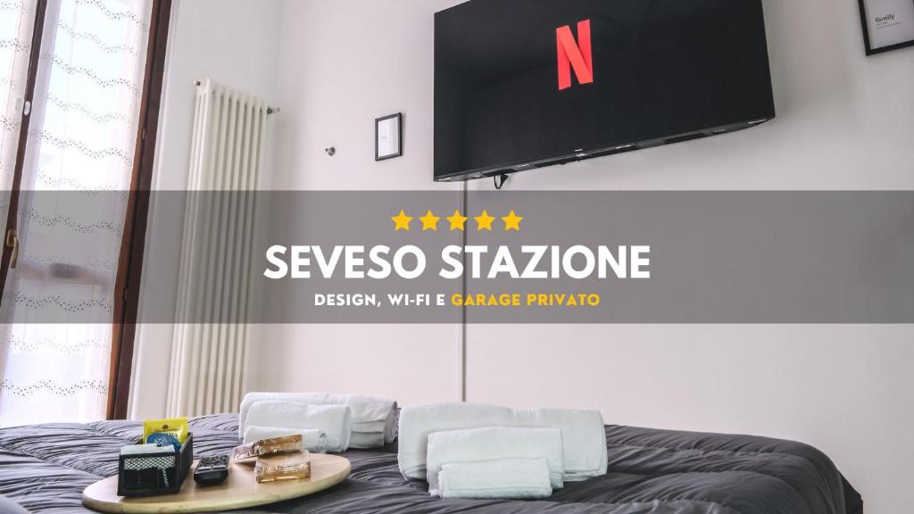 Zimmer mit einem Bett mit zwei weißen Stühlen und einem TV in der Unterkunft [Seveso-Stazione] Design, Wifi & Garage Privato in Seveso