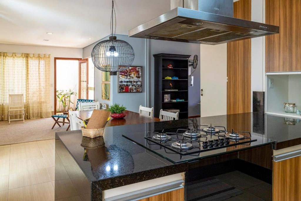 - une cuisine avec un comptoir noir et une cuisinière dans l'établissement Ótima localização a 600 m shopping Esmeralda, à Marília