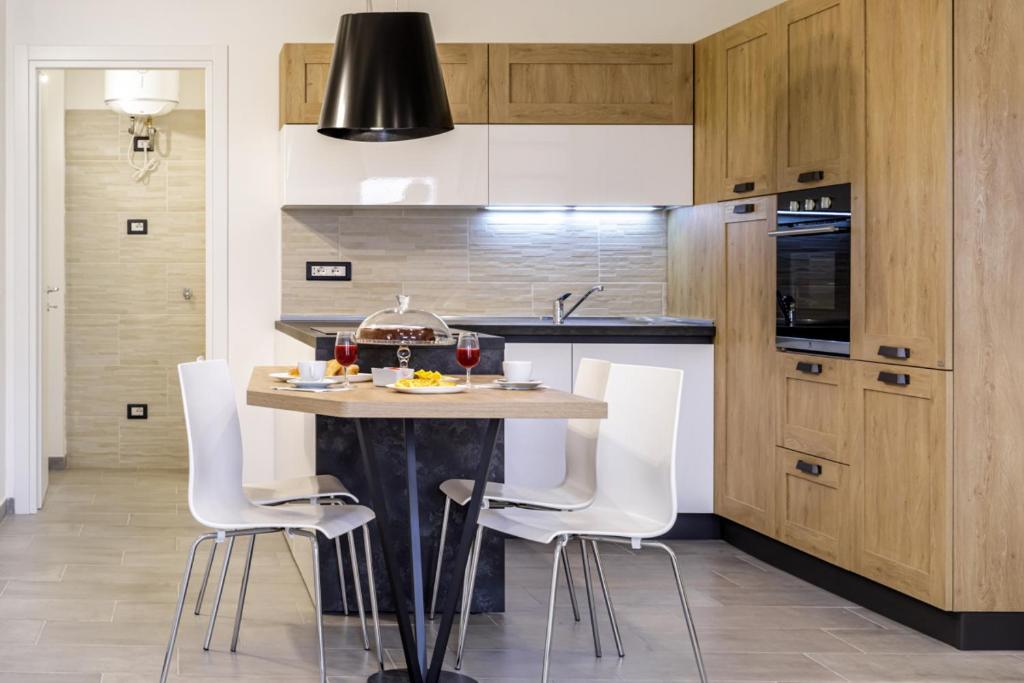 una cucina con tavolo e sedie bianche di Bandiera 68 Apartment a Cagliari