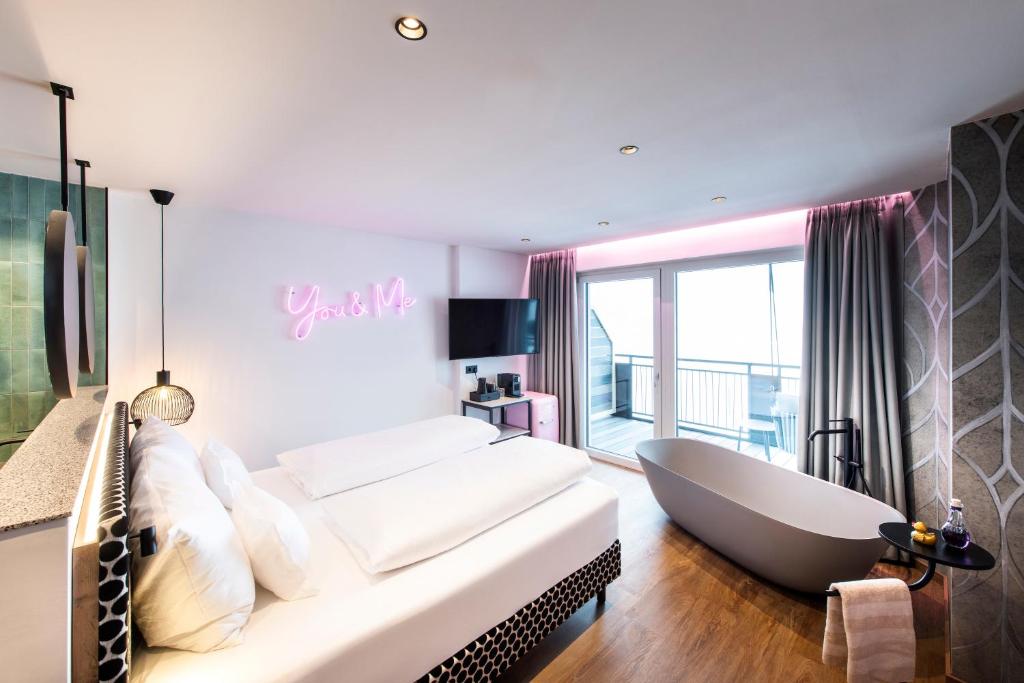 a bedroom with a large bed and a bath tub at Berghotel Hochfügen in Hochfugen